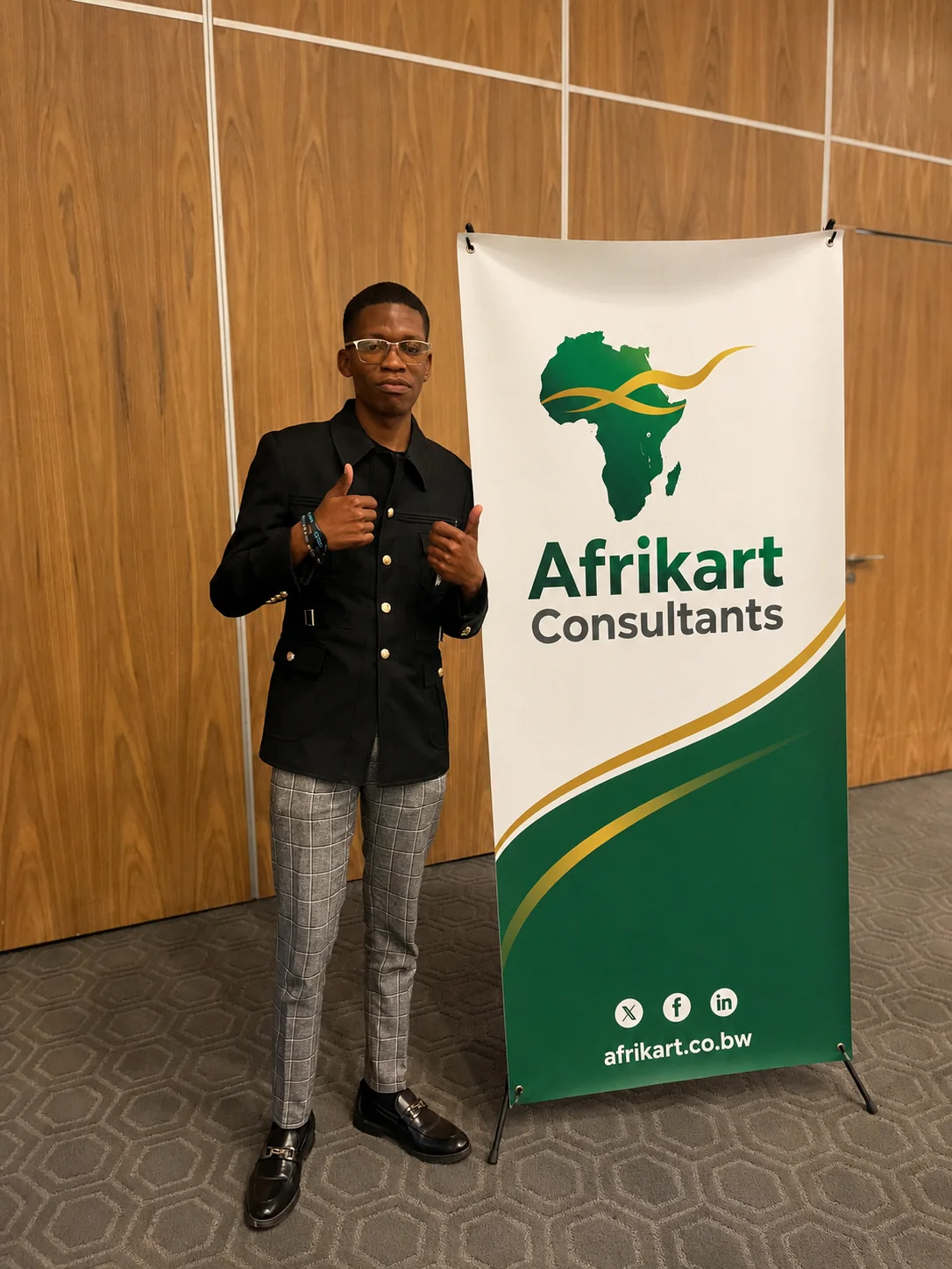Bonno Tshwene giving a thumbs-up beside an Afrikart Consultants banner