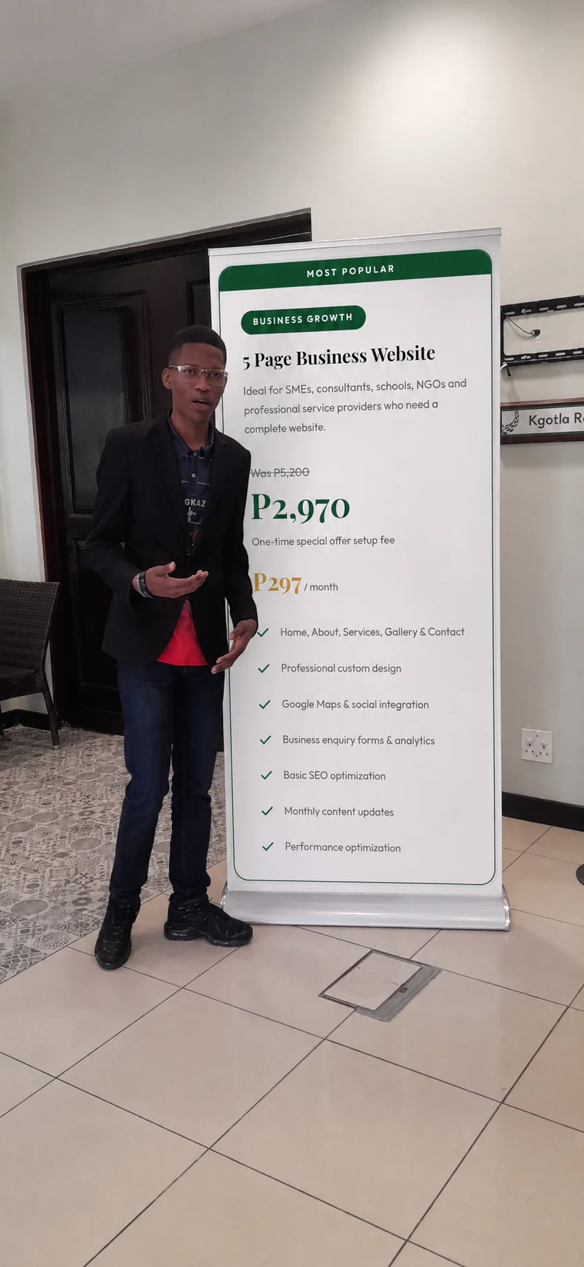 Afrikart Consultants founder beside a company roll-up banner